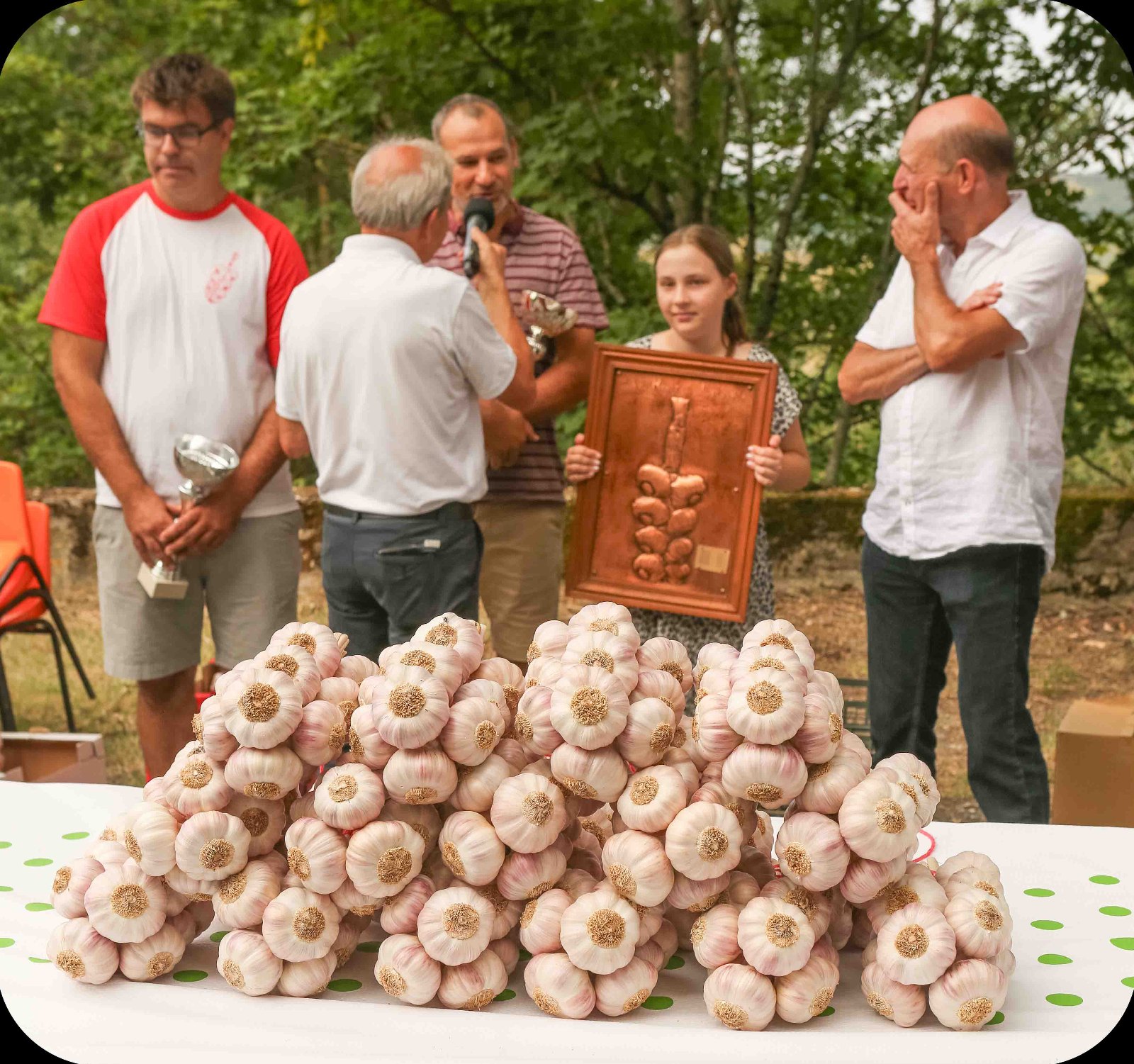 La famille de La Lautrecoise recevant le 1er prix 2024 du concours des producteurs, devant des têtes d'ail rose de Lautrec